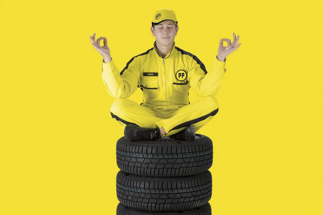 Image-Kampagne, gelber Renn-Overall, Reifenstapel