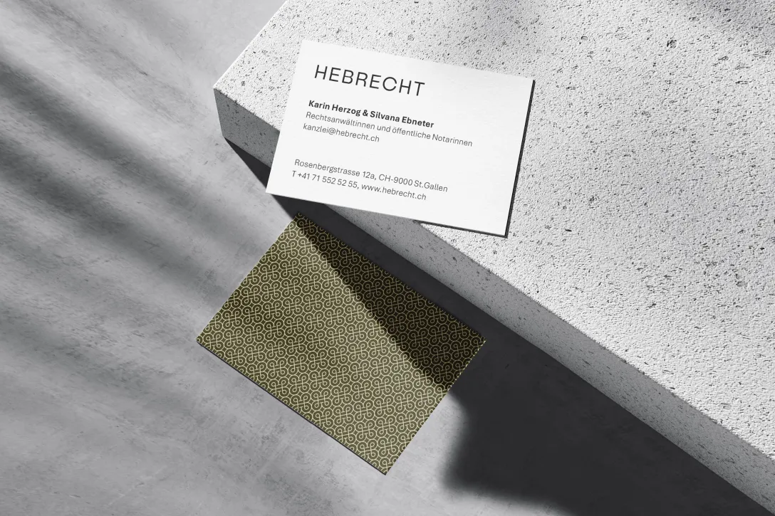 Minimalistische Visitenkarte Hebrecht auf Beton, schwarze Typografie, goldfarbenes Muster, Corporate Design für Kanzlei